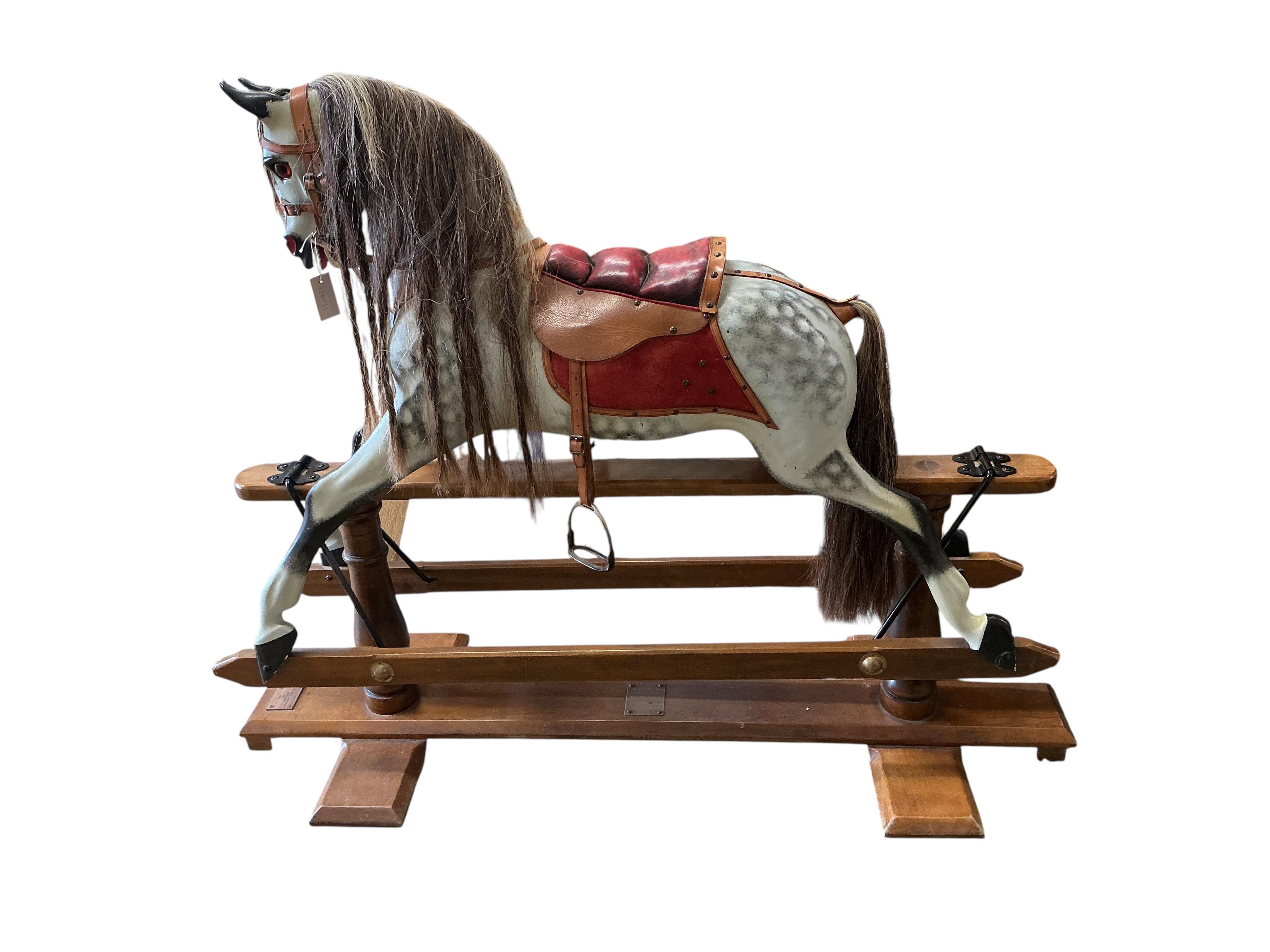 A Stevenson Brothers late 20th century dappled grey rocking horse, on a stained wood base with padded saddle, Stevenson plaque to the base dated 1994, together with a serial number 1519, additional plaque with dedication